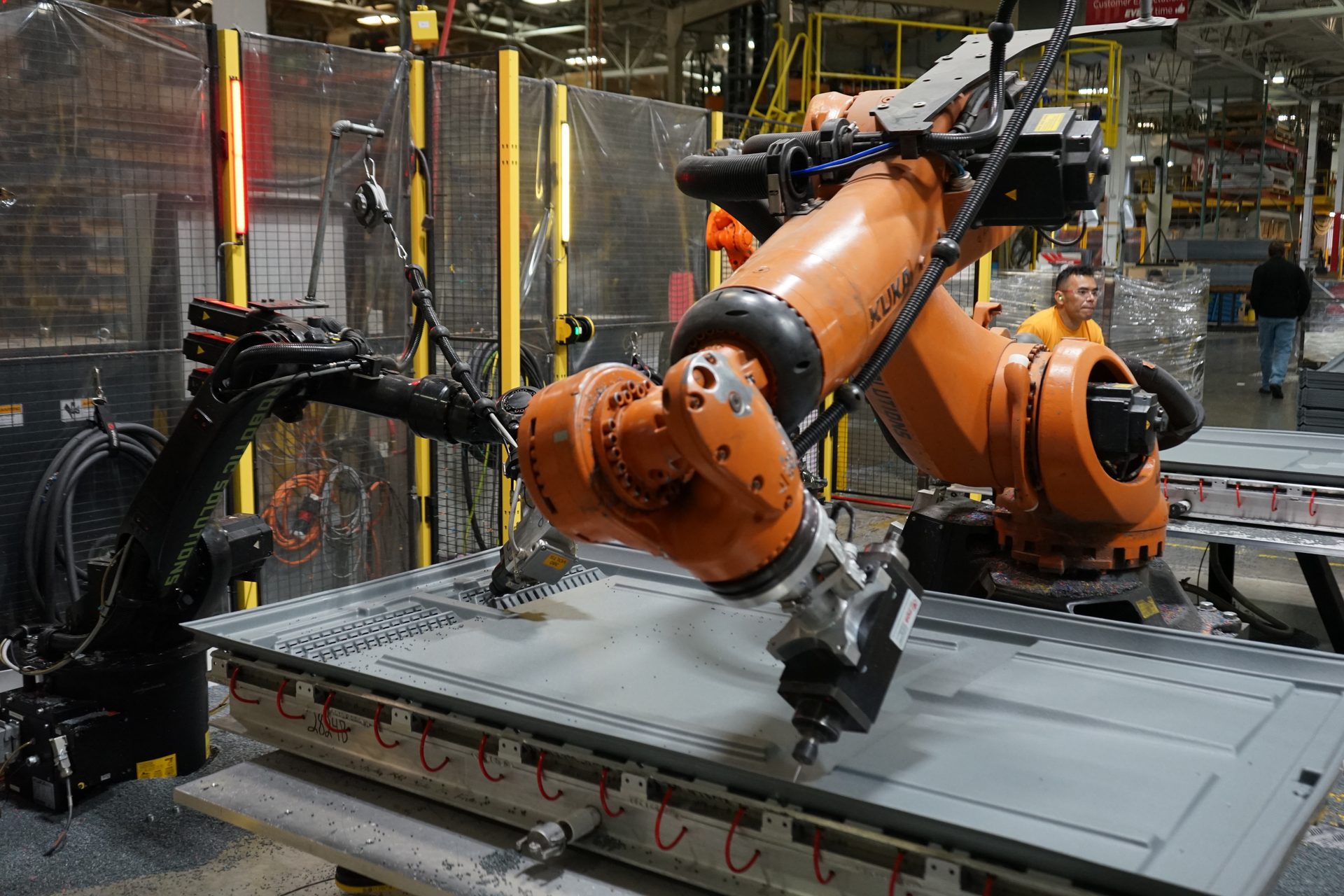 A KUKA robot trimming a large formed part in Hampel's trim cell